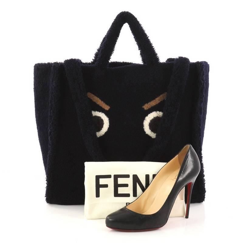 This authentic Fendi Faces Tote Shearling Large features a playfully striking detail elaborating the elegantly decadent spirit of the brand. Crafted from navy blue shearling with eyes and mouth detailing, this chic tote features dual shearling