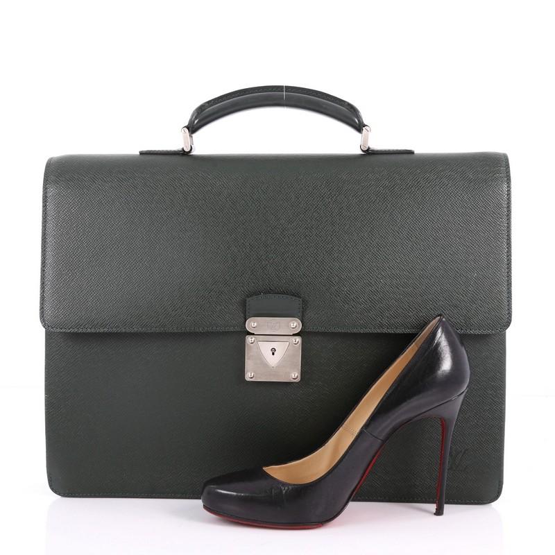 This authentic Louis Vuitton Laguito Handbag Taiga Leather combines style and functionality ideal for work. Crafted from dark green taiga leather, this structured briefcase features a leather handle, subtle LV logo, S-lock flap closure, subtle LV