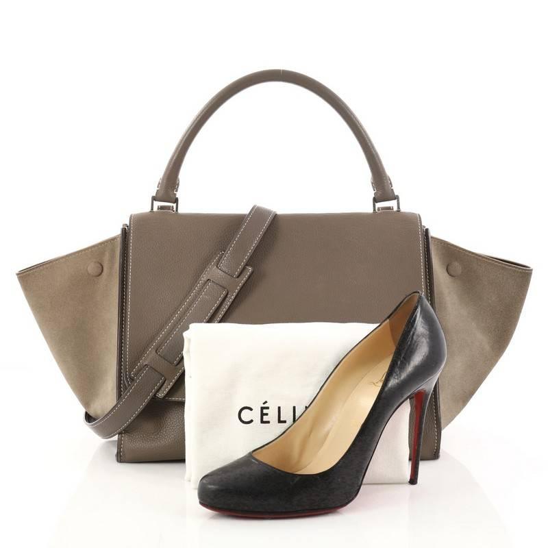 This authentic Celine Trapeze Handbag Leather Medium is a fashionista's dream. Crafted in taupe leather with matching suede wings, this classic bag features silver-tone hardware accents, exterior back pocket and top handle with removable shoulder