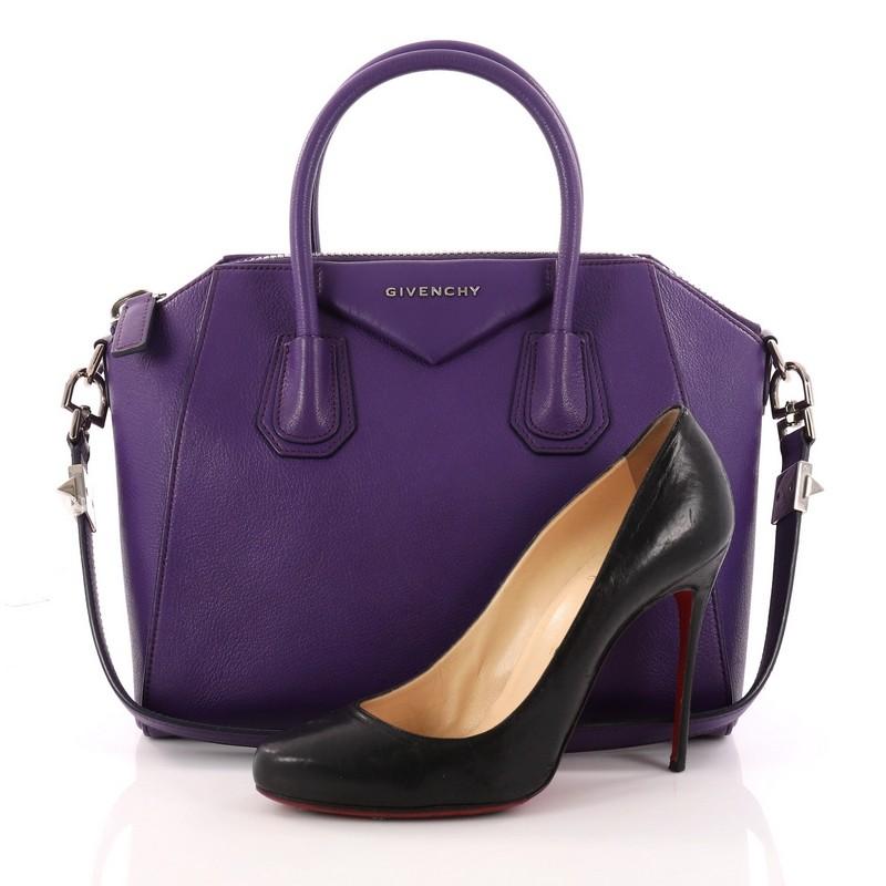 This authentic Givenchy Antigona Bag Leather Small combines style and functionality all-in-one. Crafted from sleek purple leather, this structured handle bag features dual-rolled leather handles and silver-tone hardware accents. Its zip-top closure