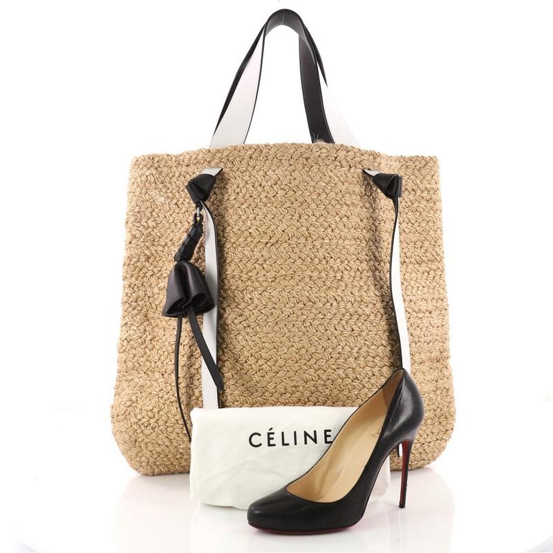 This authentic Celine Basket Tote Straw with Leather XL is the perfect getaway accessory. Crafted in woven straw, this stylish bag features black and white smooth calfskin leather trim, dual flat shoulder straps with knot accents and silver-tone