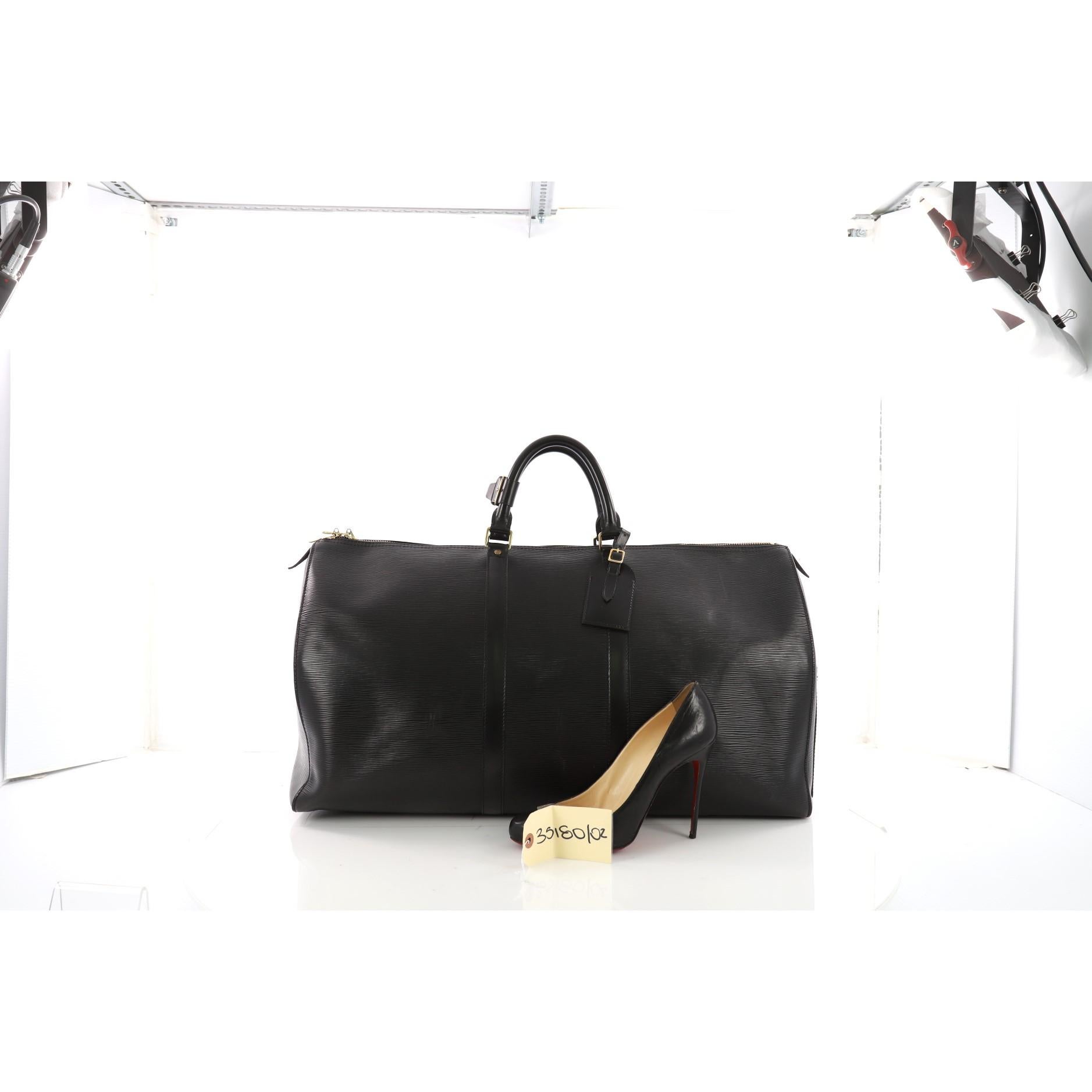This authentic Louis Vuitton Keepall Bag Epi Leather 60 is the brand's timeless travel bag. Constructed from black epi leather, this iconic Keepall is accented with dual-rolled leather handles, subtle LV logo, exterior slip pocket and gold-tone