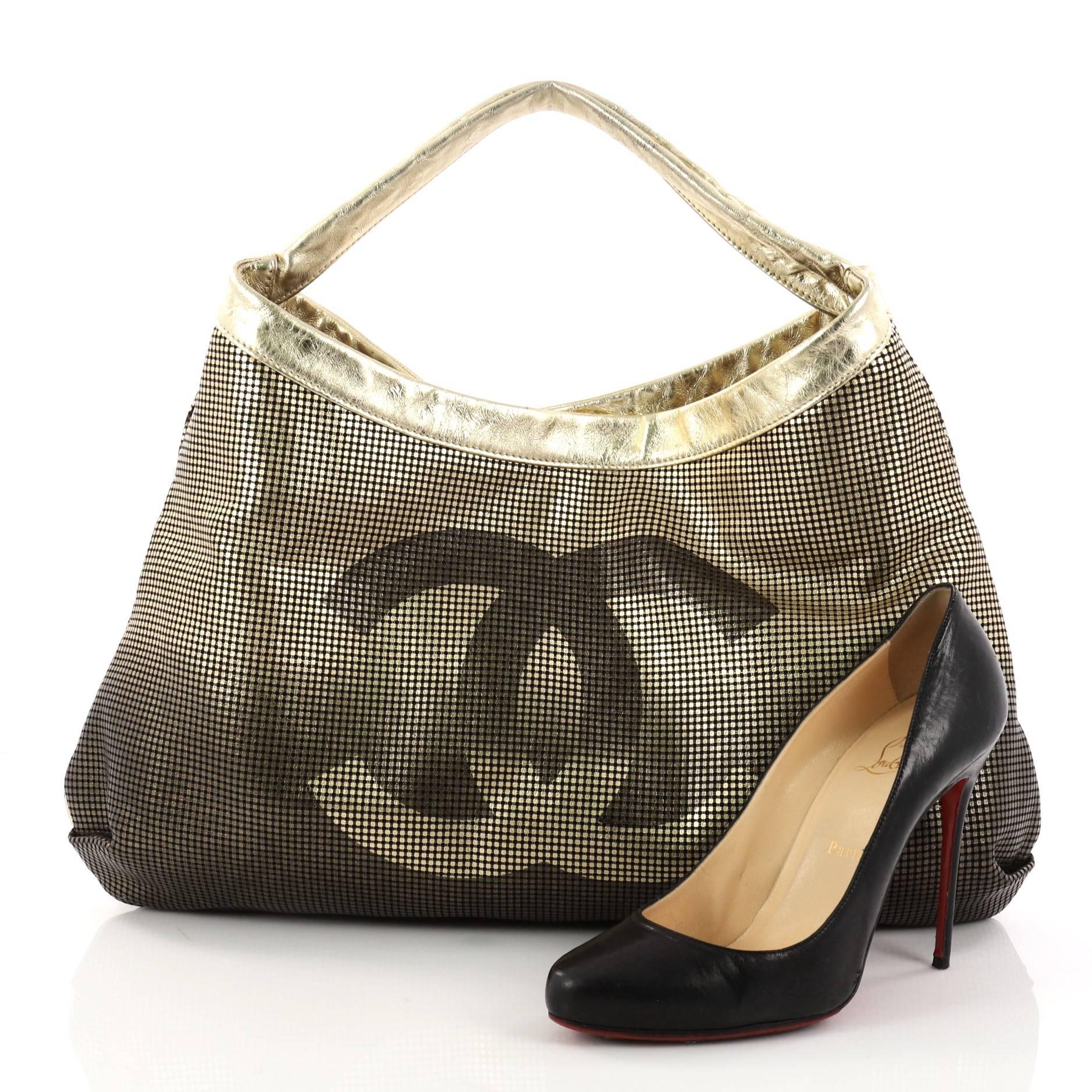 This authentic Chanel Hollywood Hobo Perforated Leather East West is a chic sports-inspired look made for everyday use. Crafted from metallic gold and black ombre perforated leather, this hobo features frontal Chanel CC logo, gold leather shoulder