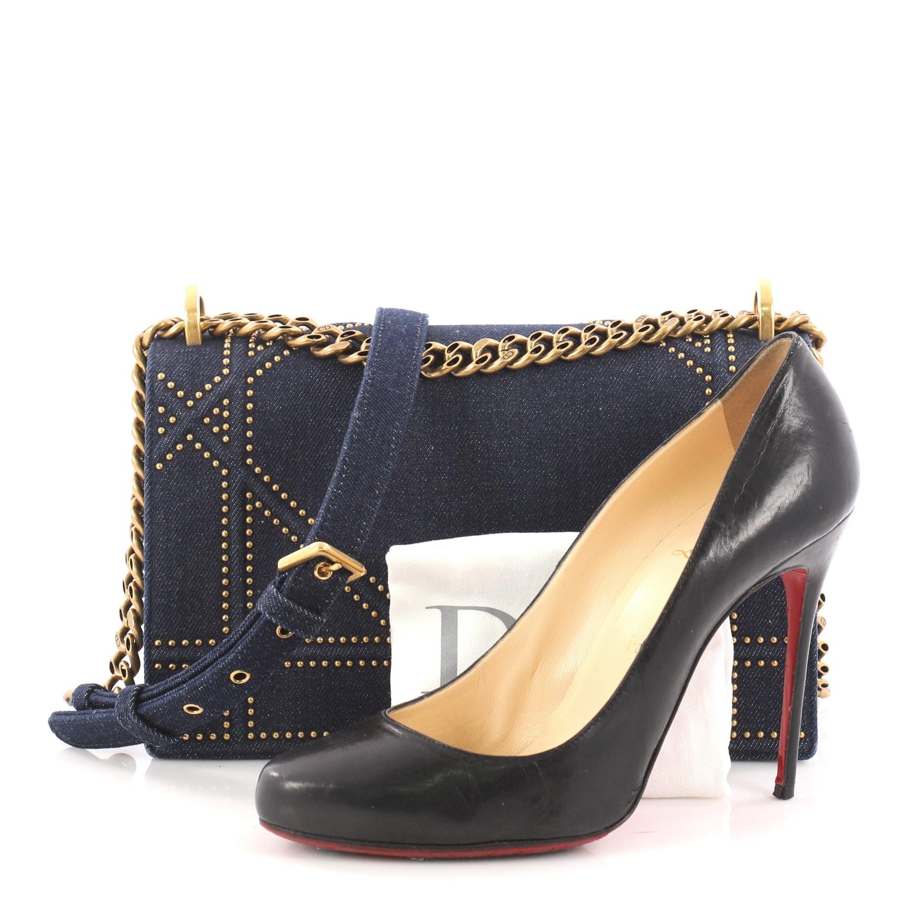 This authentic Christian Dior Diorama Flap Bag Studded Denim Medium is a new classic from Dior. Crafted in blue denim, this architectural flap bag features an oversized graphic-style cannage quilt design with multiple aged gold studs, chunky chain
