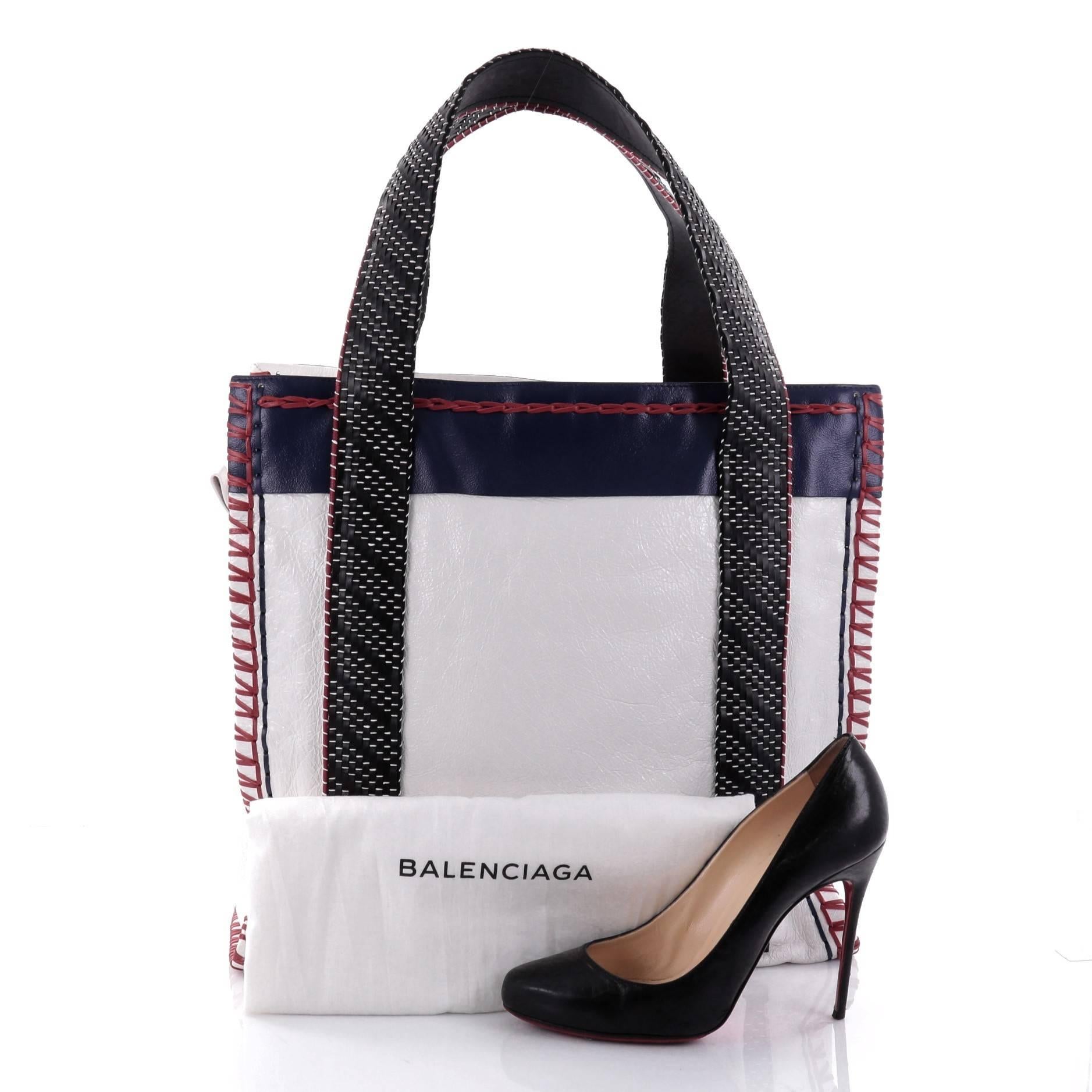 This authentic Balenciaga Scaffold Shopper Tote Whipstitch Leather Medium is a stylish and unique bag that's a perfect addition to the house's coveted bag collection. Crafted in white leather with navy leather panels, this bag features dual flat