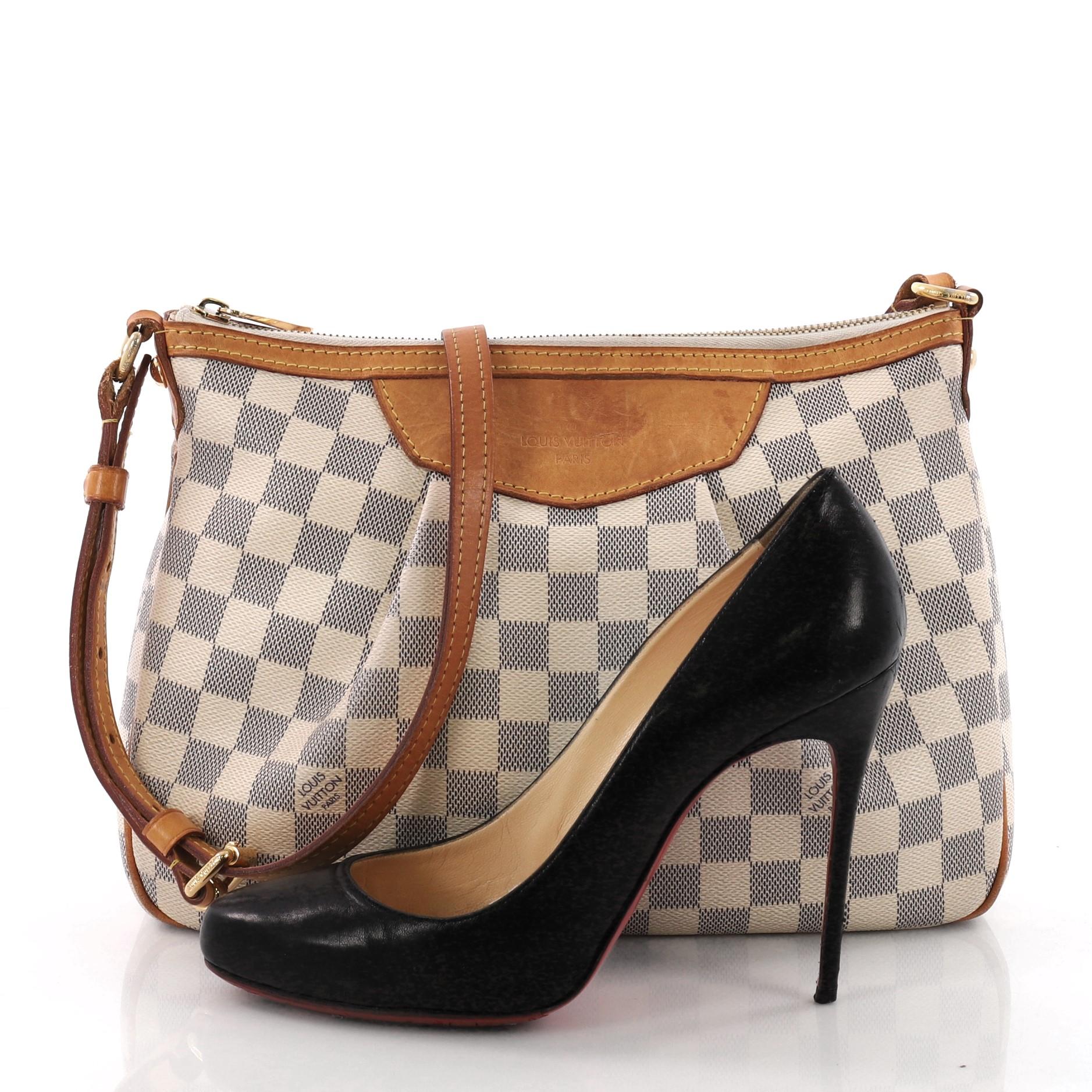 This authentic Louis Vuitton Siracusa Handbag Damier PM inspired by the historic Italian city, is perfect for on-the-go fashionistas. Crafted in damier azur coated canvas, this functional crossbody features a feminine pleated silhouette, vachetta