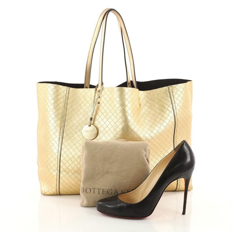 This authentic Bottega Veneta Intrecciomirage Tote Leather Large is a classic styled Bottega bag perfect for your everyday use. Crafted from gold intrecciomirage leather, this bag features dual tall leather top handle, and matte gunmetal-tone