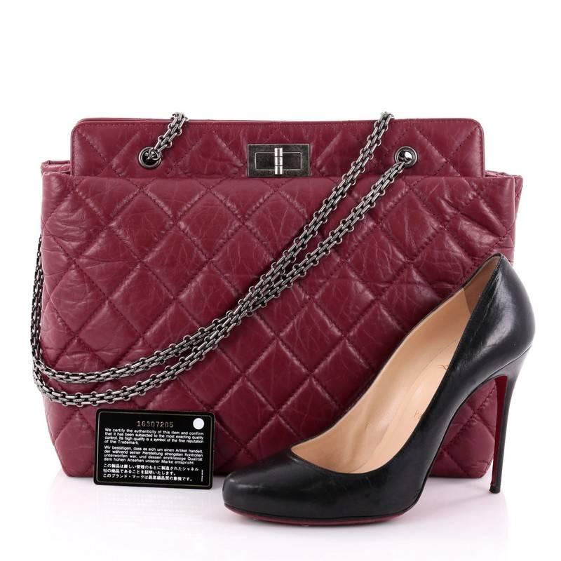 This authentic Chanel Reissue Tote Quilted Aged Calfskin Large is eye-catching and understated showcasing a reinterpretation of the brand's classic reissue design. Crafted in vivid red diamond quilted aged calfskin leather, this slightly puffed tote