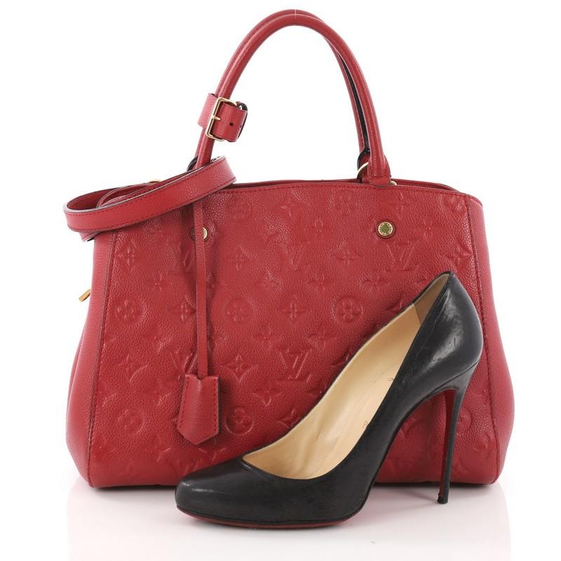 This Louis Vuitton Montaigne Handbag Monogram Empreinte Leather MM, crafted in red monogram empreinte leather, features dual-rolled leather handles, protective base studs and gold-tone hardware accents. Its hook closure opens to a red fabric