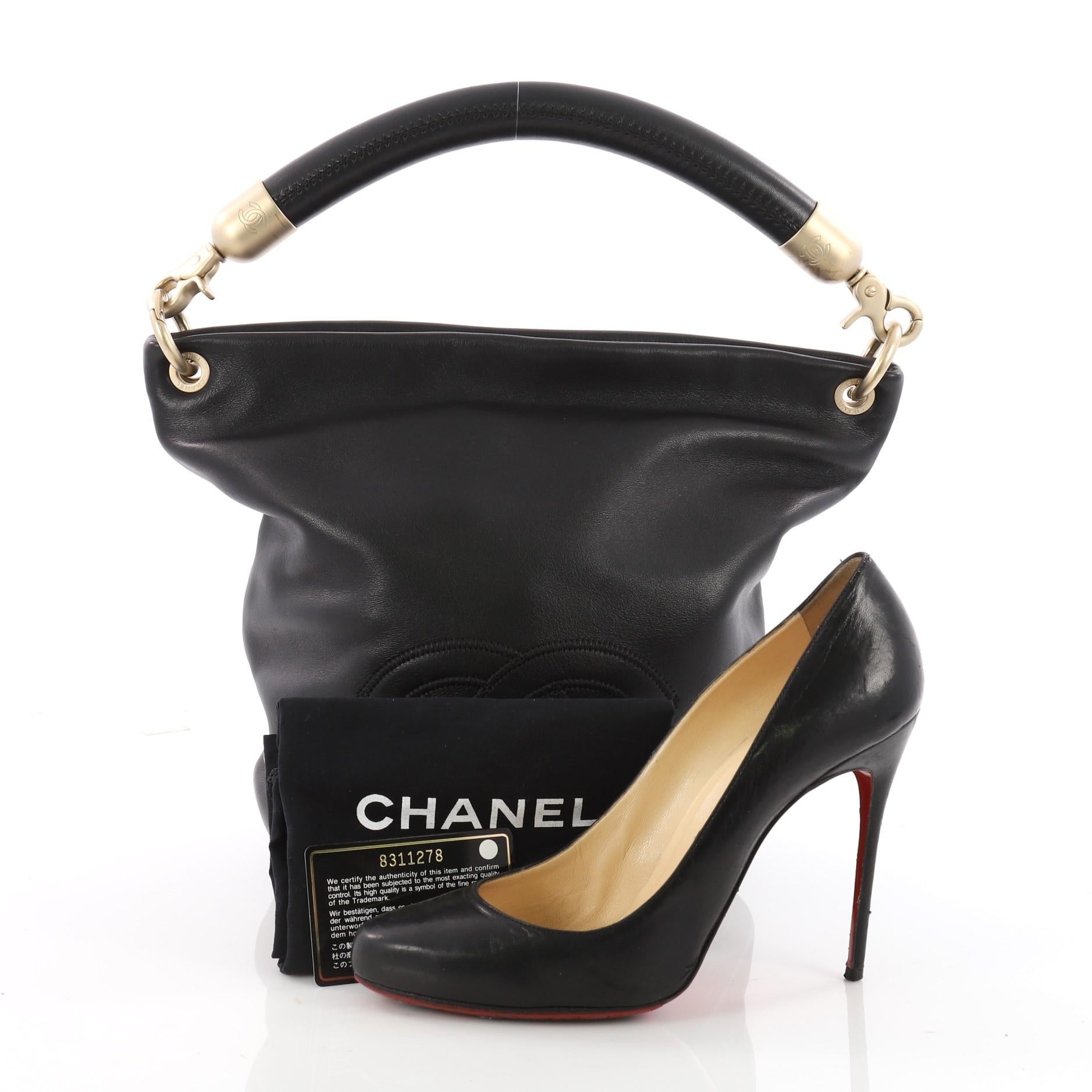 This authentic Chanel Vintage CC Handle Bucket Bag Leather Medium showcases an elegant and timeless design made for Chanel lovers. Crafted in black leather, this tote features a looping leather handle, CC stitched logo at front, round base and gold