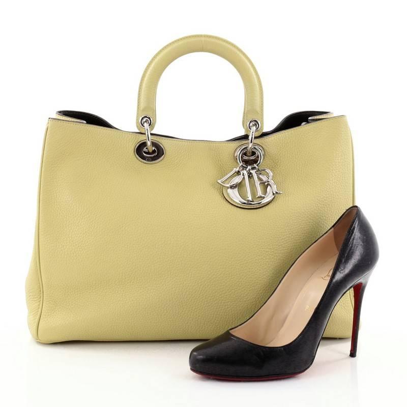 This authentic Christian Dior Diorissimo Tote Pebbled Leather Large is an elegant, classic statement piece that every fashionista needs in her wardrobe. Crafted from citron pebbled leather, this chic tote features smooth short dual handles with