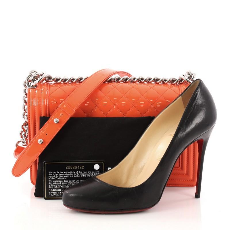 This authentic Chanel Boy Flap Bag Quilted Plexiglass Patent Old Medium is every woman's dream. Crafted from a striking orange quilted patent leather, this enviable Boy flap bag features a chunky chain link strap with shoulder pad, frontal unique