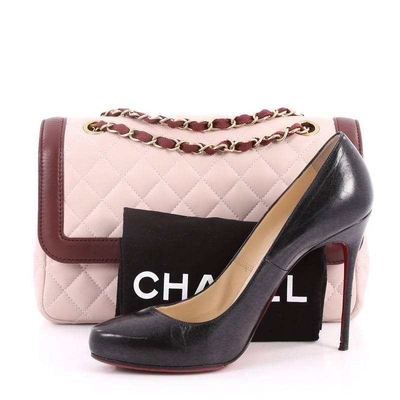 This authentic Chanel Two Tone Flap Bag Quilted Lambskin Medium is a timeless, iconic bag that can be used from day to night. Crafted from light pink quilted leather with burgundy leather trims, this vintage bag features gold woven-in leather chain