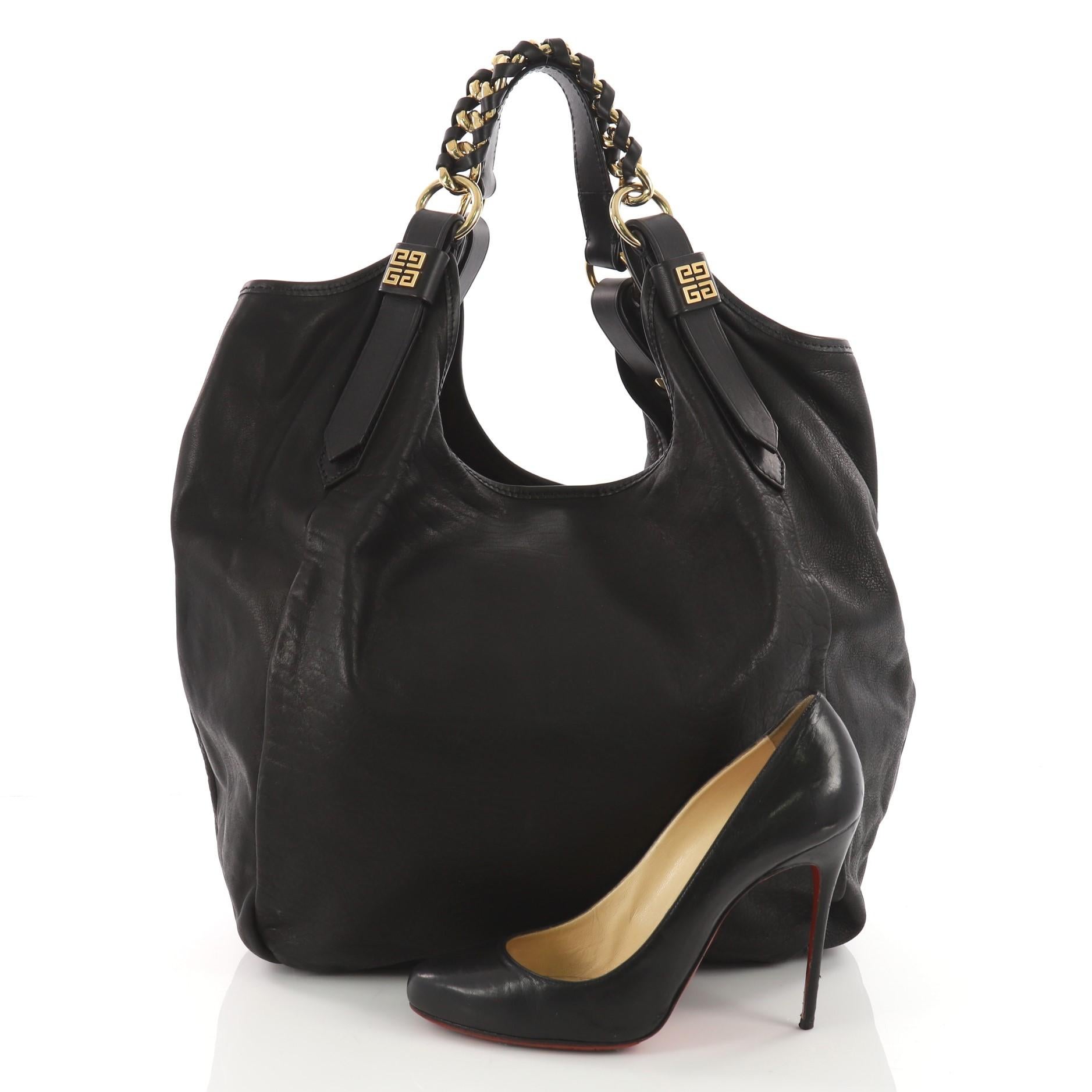 This authentic Givenchy Sacca Shoulder Bag Leather Medium is modern yet casual in design ideal for day to day use. Crafted in black leather, this edgy bag features chain and leather handles with gold Givenchy button accents. Its magnetic snap