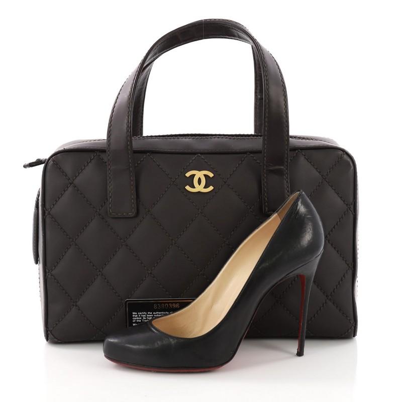 This Chanel Surpique Zip Around Satchel Quilted Leather Medium, crafted in dark brown quilted leather with surpique stitching, features dual flat handles, protective base studs, CC detailing, and matte gold-tone hardware. Its all-around zip closure