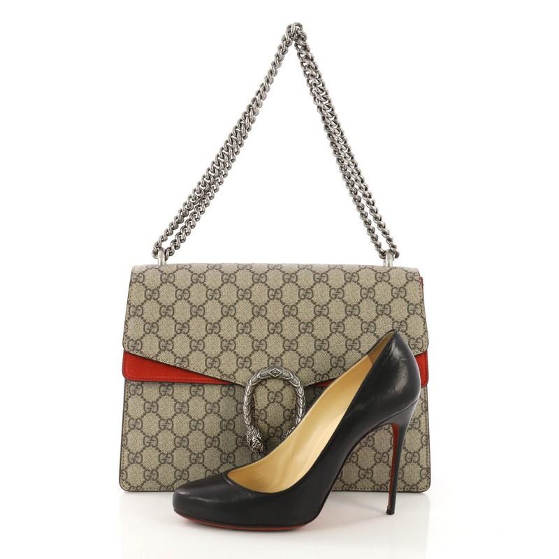 This Gucci Dionysus Handbag GG Coated Canvas Medium, crafted from taupe GG coated canvas, features chain link strap, textured tiger head spur detail on its flap, and silver-tone hardware. Its hidden push-pin closure opens to a red suede interior