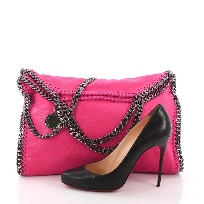 This Stella McCartney Falabella Fold Over Bag Shaggy Deer, crafted in pink shaggy deer, features gunmetal chain link handles and trim, whipstitched edges, a hanging logo disc, and gunmetal-tone hardware. Its magnetic snap closure opens to a dusty