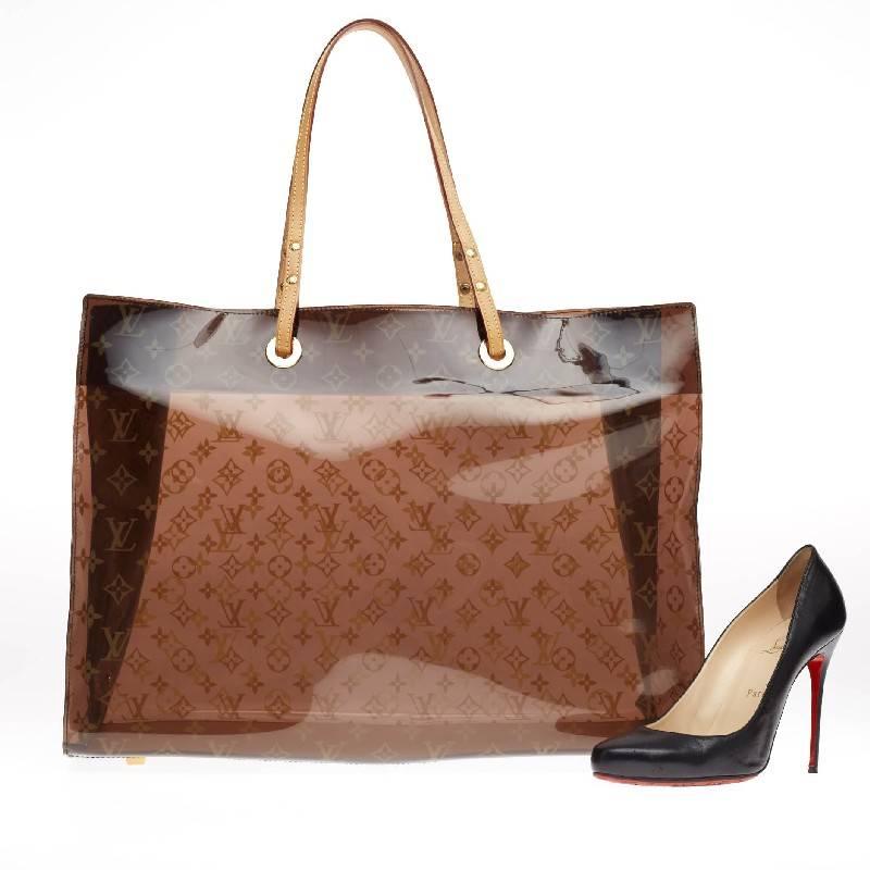 This authentic Louis Vuitton Ambre Sac Cabas Monogram Vinyl GM showcases a playful design perfect for casual days. Constructed from monogram ambre vinyl and accented with cowhide leather trims, this oversized, stylish tote features vachetta leather