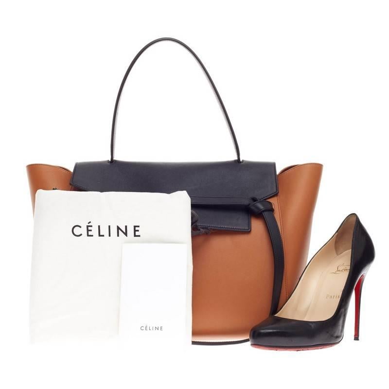 This authentic Celine Belt Bag Bicolor Leather Small presented in the brand's Fall 2014 Collection is sure to make a statement. Crafted from two-tone burnt orange and black smooth calfskin leather, this bold and sleek belt bag features expanded