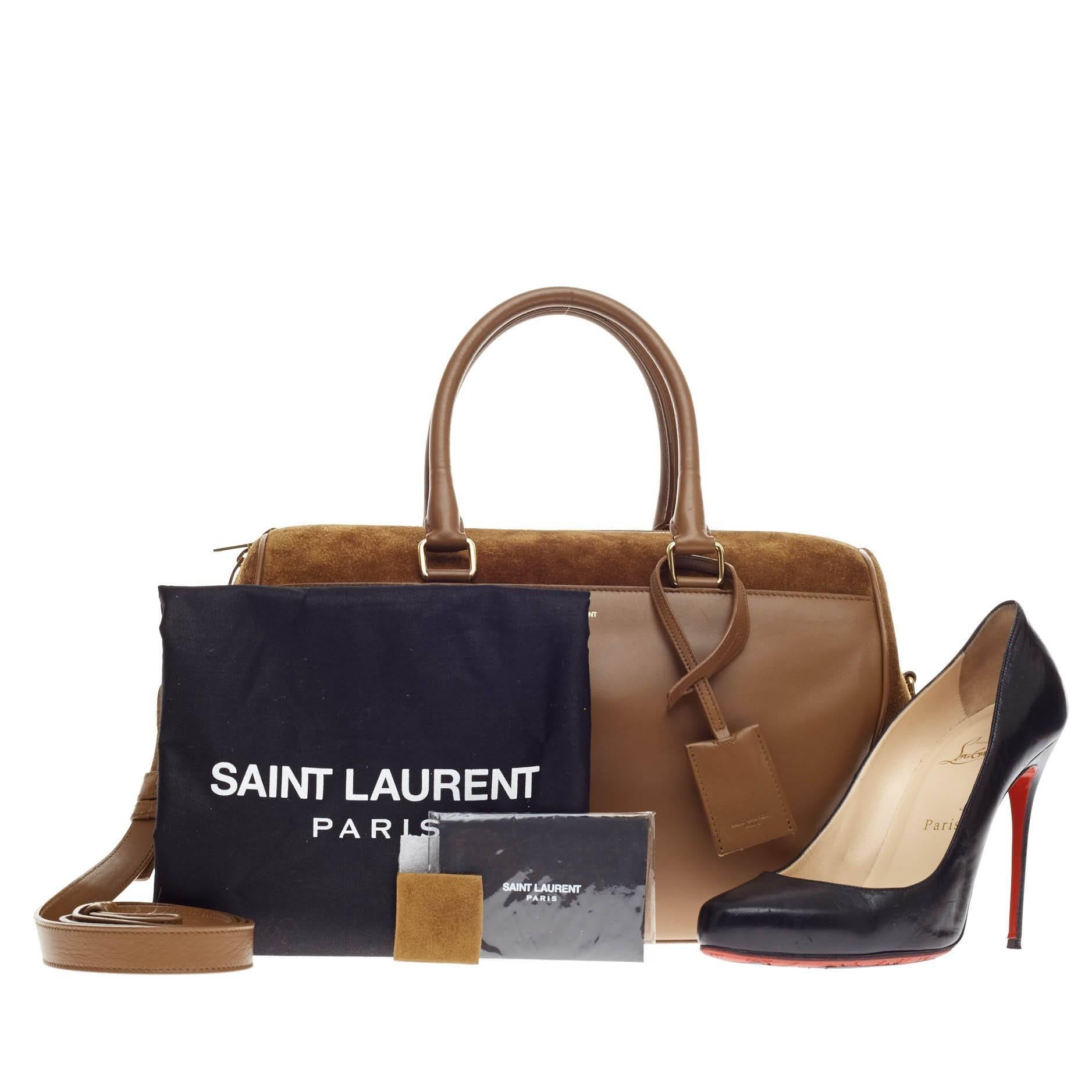 This authentic Saint Laurent Classic Duffle Suede and Leather 6 is a modern and elegant duffle bag to travel in style with. Crafted in contrasting suede and leather in beautiful ochre brown, this alluring bag features dual-rolled leather handles,