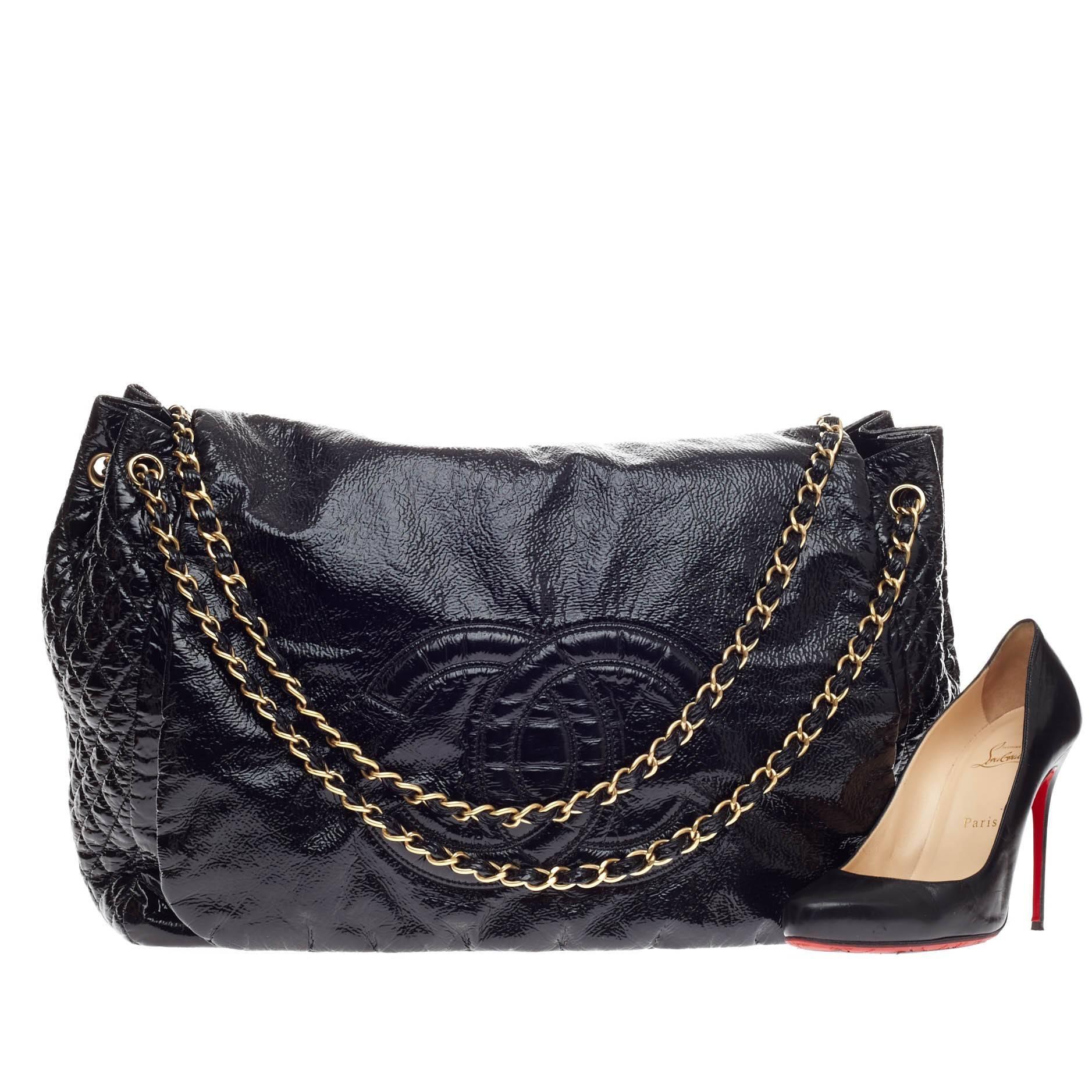 This authentic Chanel Rock and Chain Flap Bag Patent Large boasts a large stature perfect for Chanel lovers. Crafted in distressed black patent vinyl fabric, this rommy tote features signature woven-in leather chain straps, large CC stitched design