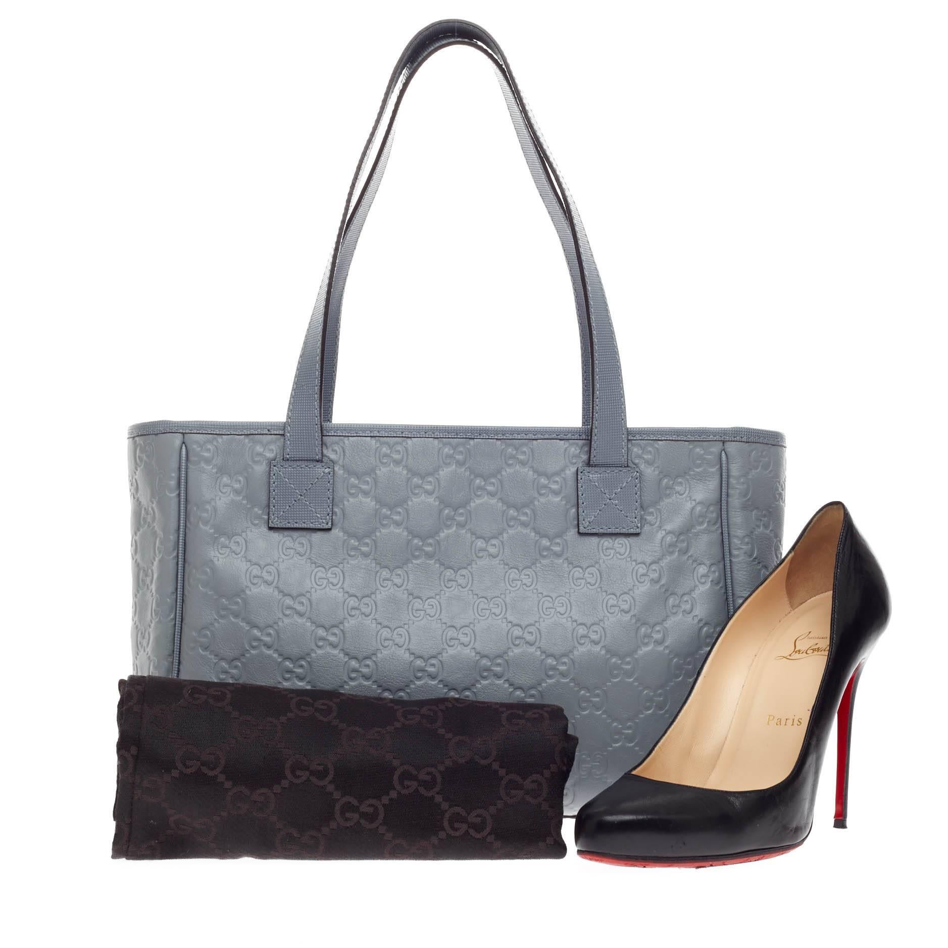 This authentic Gucci Slit Pocket Tote Guccisima Leather Medium is ideal for everyday use. Crafted in light blue guccisima leather, this simple yet chic features dual-flat leather handles, front pocket, protective base studs and silver-tone hardware