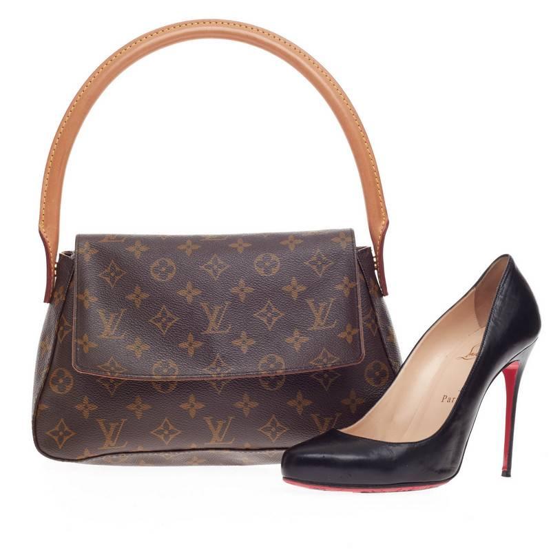 This authentic Louis Vuitton Looping Monogram Canvas Mini showcases the brand's monogram canvas print. The smallest of the Looping collection, this bag features an arched vachetta leather handle giving the bag structure and an easy top flap for