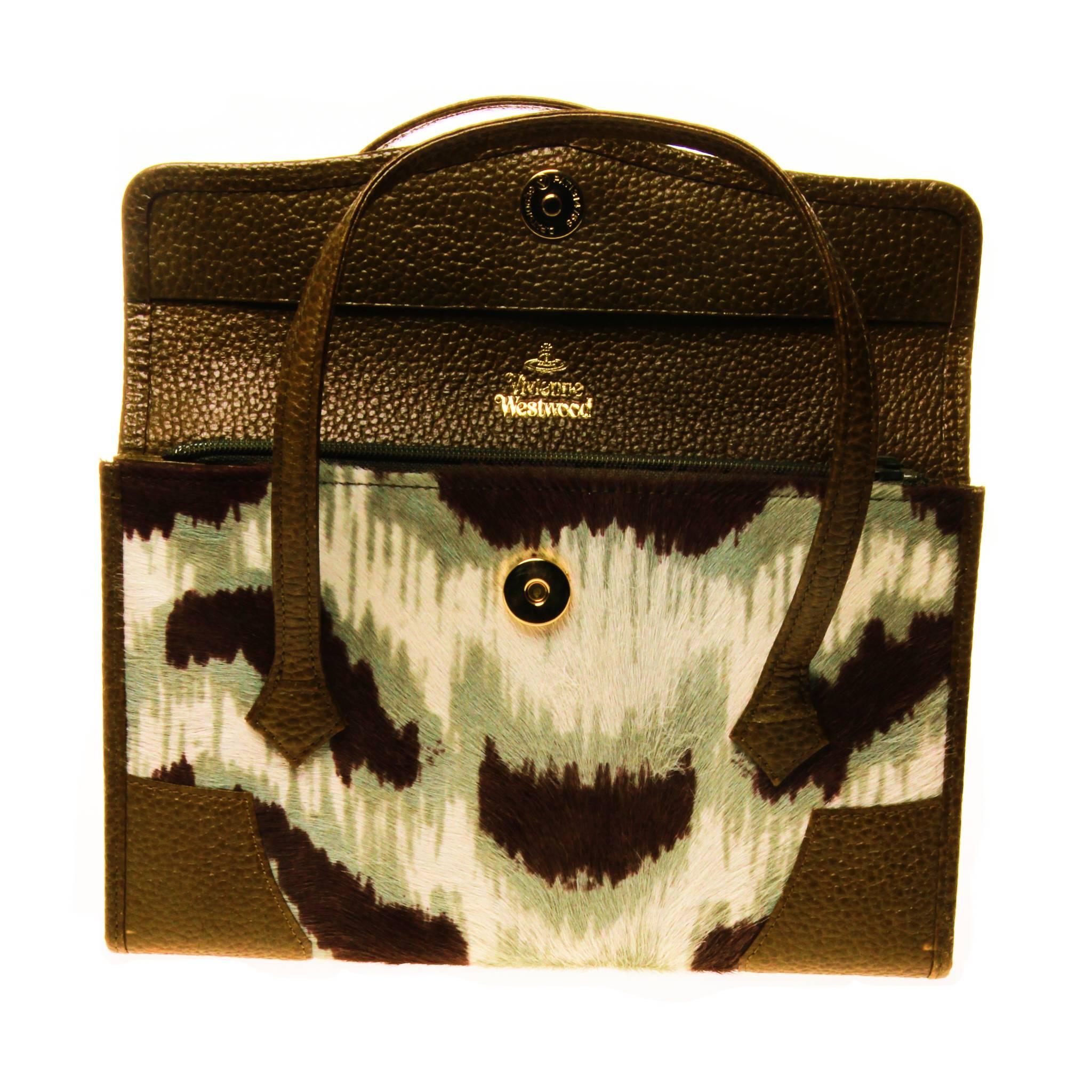 This VIVIENNE WESTWOOD printed pony hair top handle handbag is a unique and clever cross between a hand bag and a wallet. 
Beautifully crafted interior in olive green leather, features multiple compartments and card holders. A perfect travel