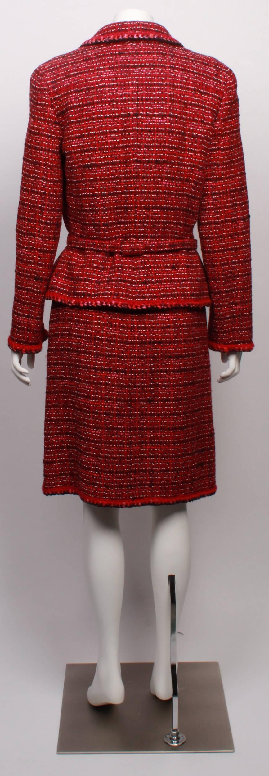 Chanel, multi tone, tweed, jacket and dress ensemble in rich tones of burgundy,
and reds. Jacket is belted, with lapels and breast pockets with a woollen crochet decorative  edging. Dress is sleeveless, with a scoop neckline, and a semi fitted