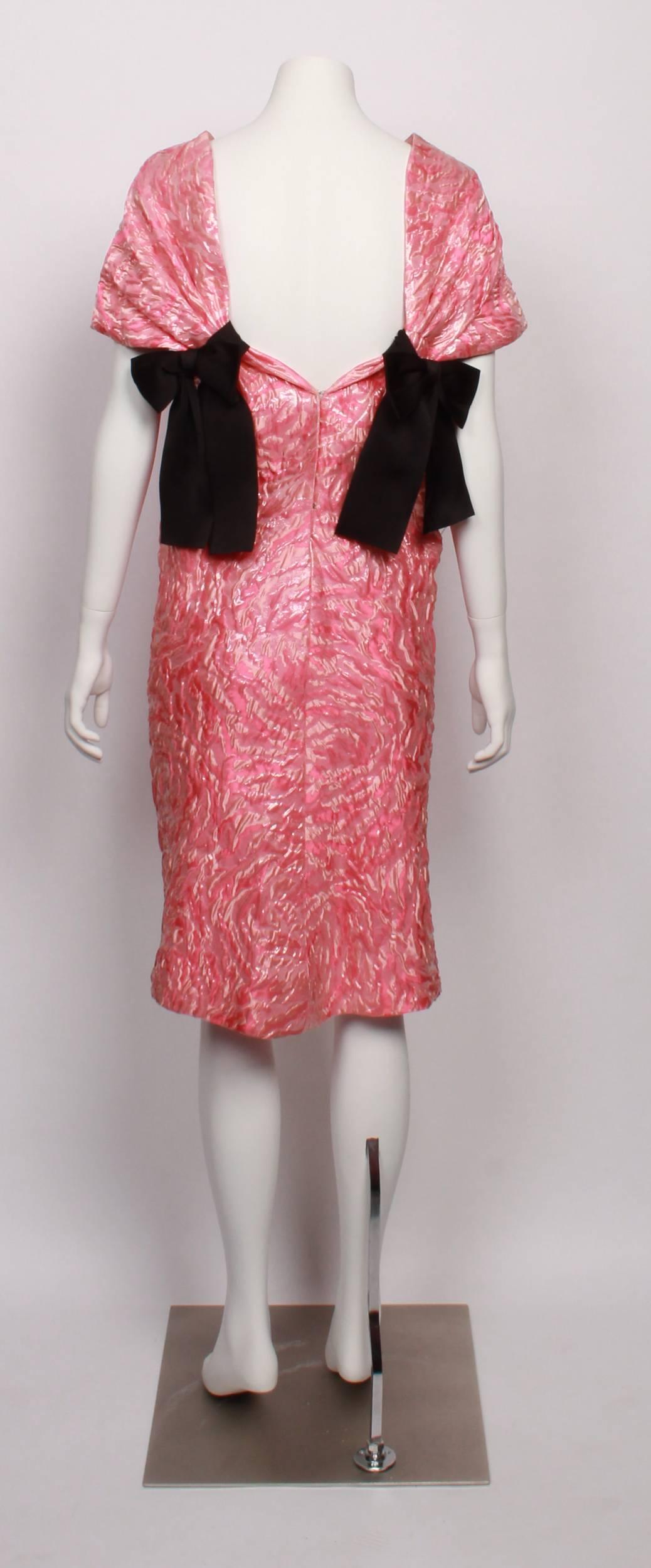 Beautiful and ultra feminine BALENCIAGA EDITION evening dress. Contemporary but true to the classic Balenciaga aesthetic. Dress is made from textured damask in pink multi shades, with black silk bow detail at back shoulder blades. Elegant boat neck