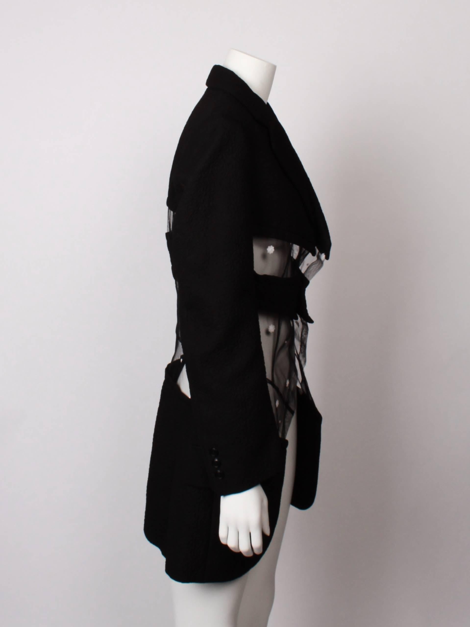 COMME DES GARCONS tailored jacket with sheer veil panels.
Solid black silk textured and fully lined panels meet with floral embroidered sheer tulle inserts. 
Solid panels are slightly padded and embroidered with a floral motif. 
Single breasted with