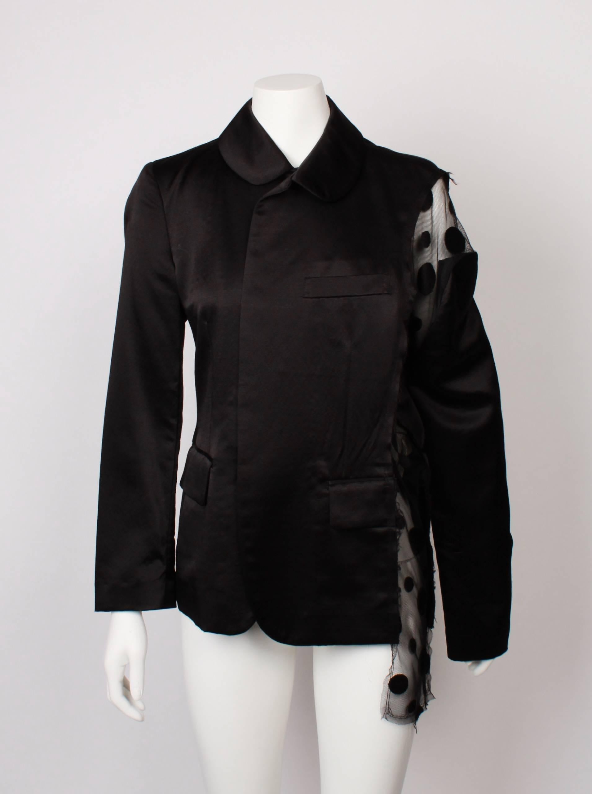 Comme Des Garcons satin evening jacket with sheer irregular spotted veil side panel. Spots are a type of velvet flock. 
Jacket features vertical flat bow belt loops and is single breasted with one functional flap pocket and breast pocket. Can be