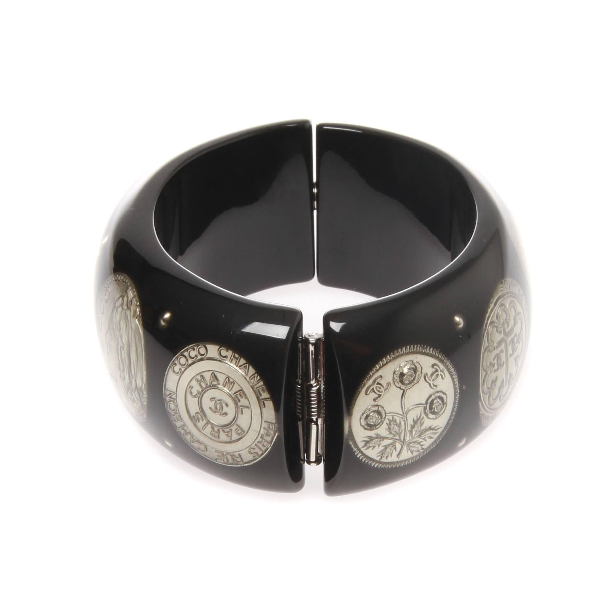 CHANEL BLACK RESIN SILVER PLATED COINS CUFF BANGLE

An exquisite black resin silver plated coins cuff bangle from the 2009 Spring CHANEL collection.
Intricately crafted with beautiful silver plated coin embellished within the black resin cuff.
It