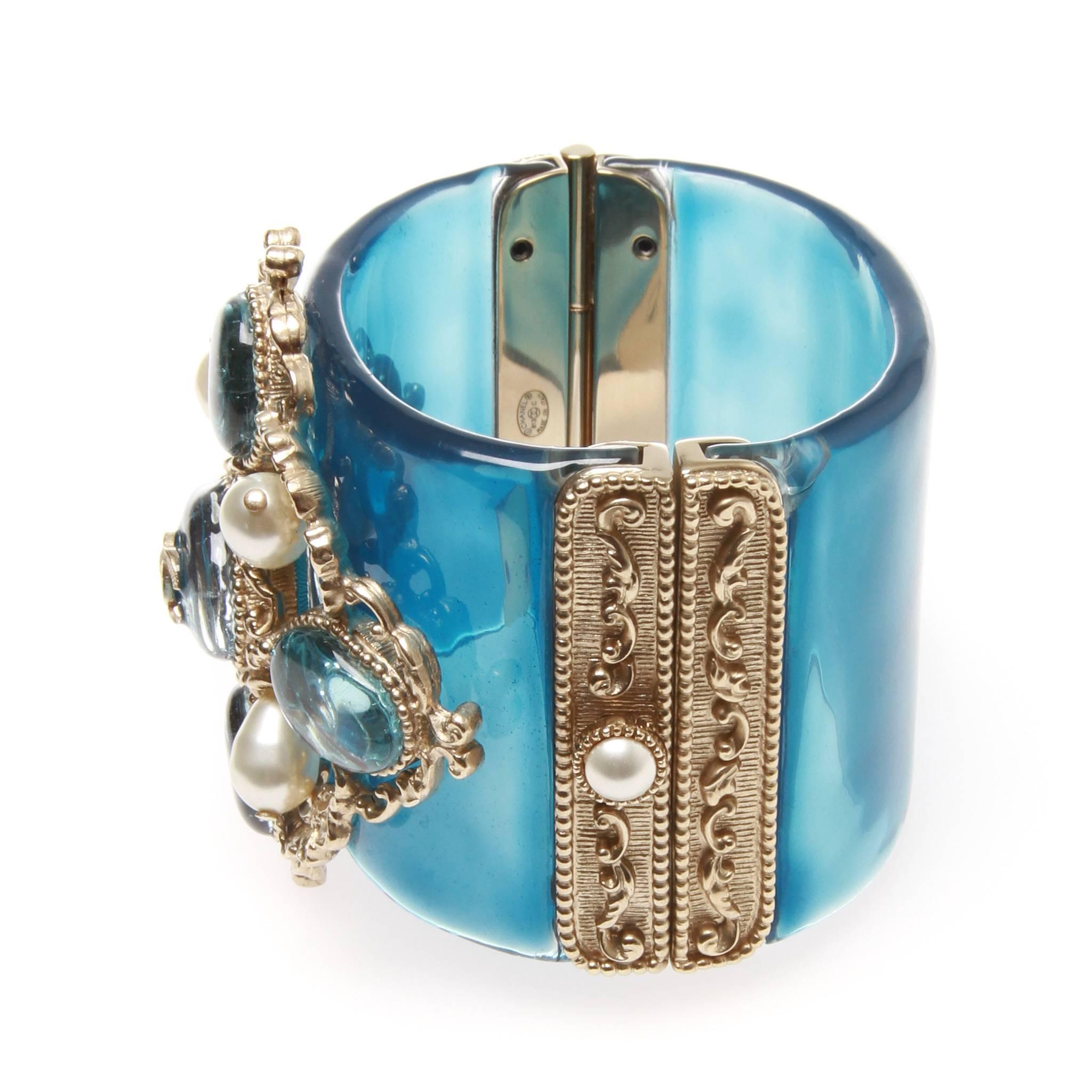 Chanel Cruise 2013 "Versailles" blue resin cuff with Gripoix jewels and pearls. Rare and coveted piece from an iconic cruise collection. Crafted of blue resin and silver filigree featuring a poured glass and pearl adornment around an