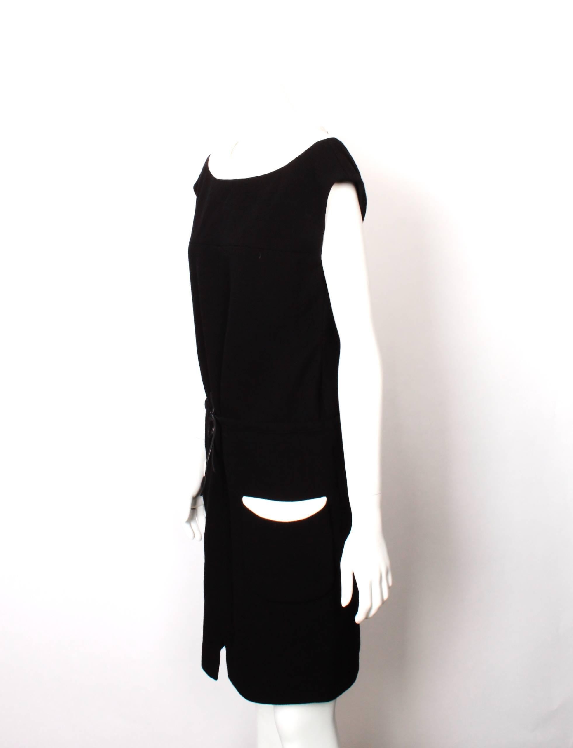 FINAL SALE
Madam Virtue & Co

CHANEL 2 Tone Dress with feature pockets and draw string waist. 
Black and ivory wool crepe with leather cord tie. Feature patch pockets are functional but have never been unpicked. Fully lined in custom Chanel embossed