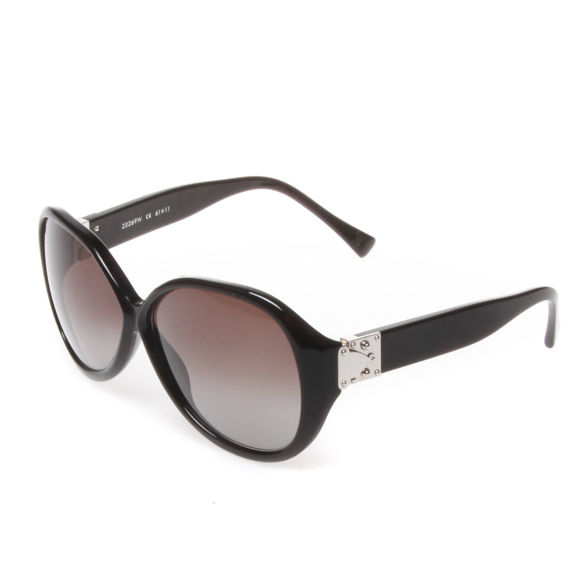 Louis Vuitton Soupçon oversized sunglasses in a black lightly glittered LV-exclusive three-layer acetate. Featuring the soupçon line's S-lock hinge design inspired by LV luggage in silver tone. The gradient tinted lenses provide 100% UV