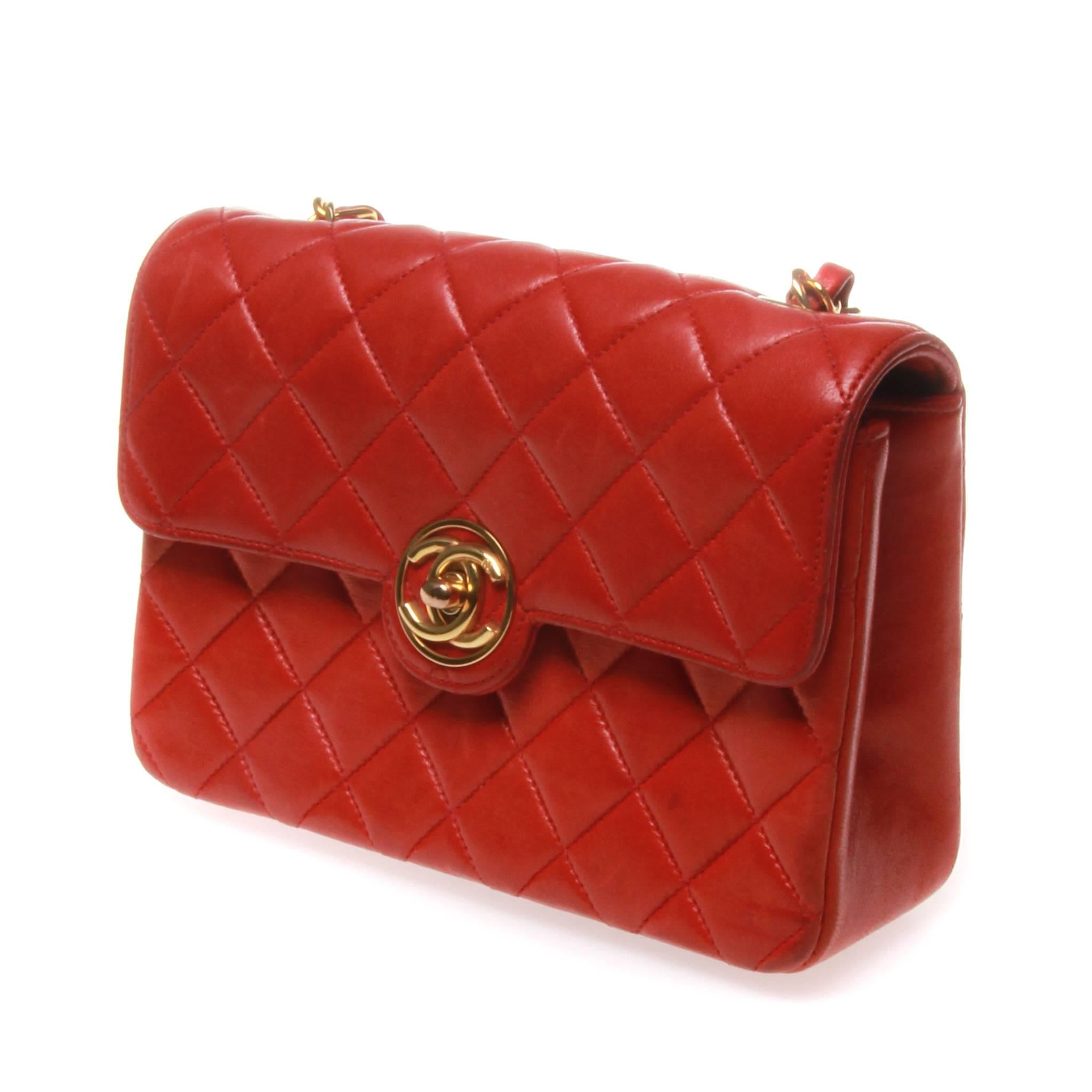 Vintage Chanel mini classic flap cross body bag in quilted red lambskin leather with gold hardware. The bag features the classic leather threaded chain shoulder strap and front flap with an encircled Chanel CC turn lock. This bag is in great vintage