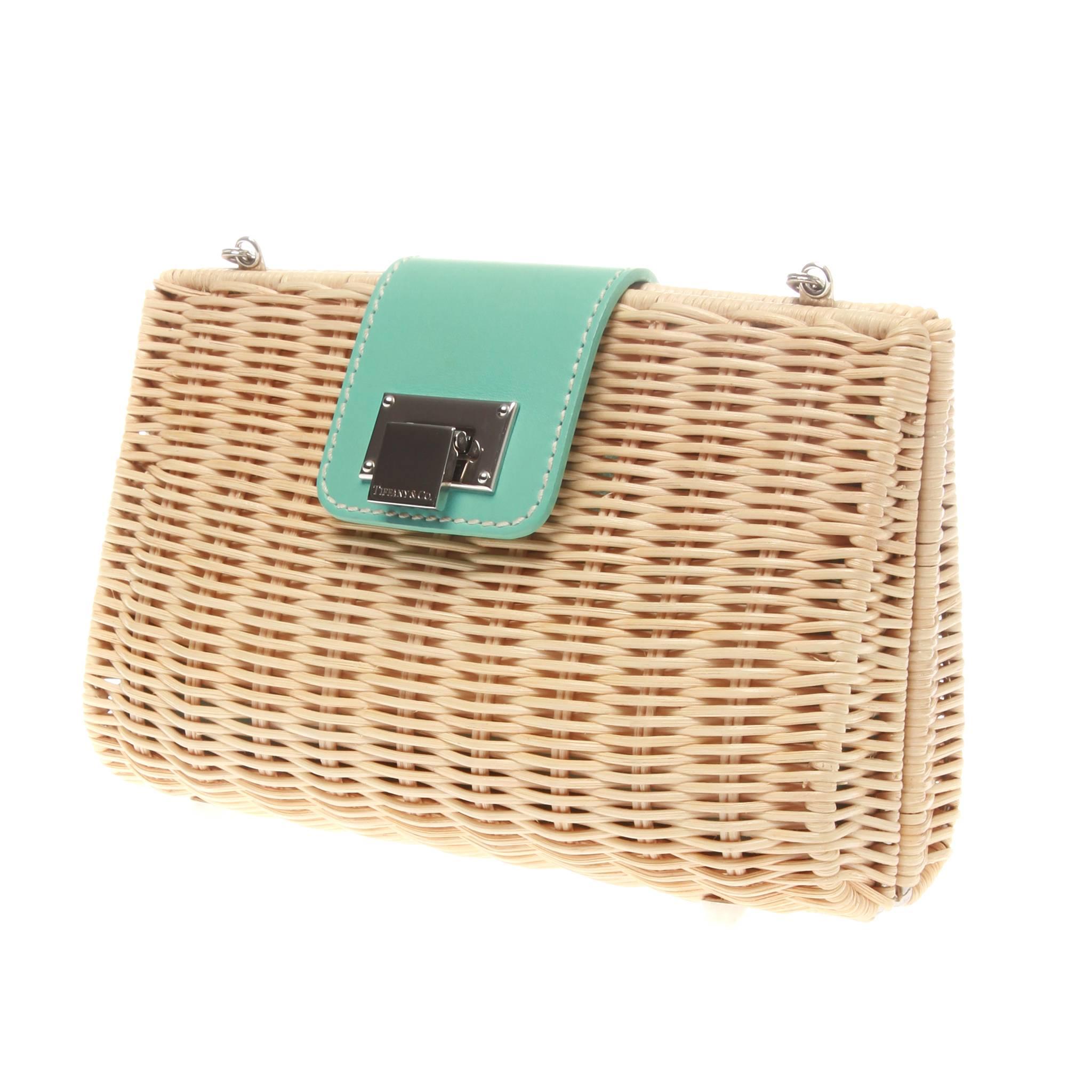 Tiffany & Co. 'Blaine' natural beige woven wicker clutch bag. Featuring supple iconic blue leather and silver-tone metal accents. Flip lock front closure opens and fastens one interior compartment, lined with Tiffany blue leather. Interior