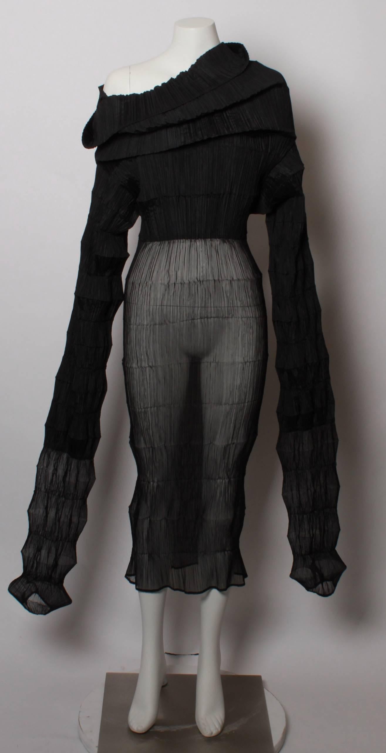 Issey Miyake rare and iconic Flying Saucer pleat dress. 
Constructed in black solid and sheer pleated polyester, the dress features a high cowl funnel neck and a maxi length sleeve that allows this piece of wearable art to be manipulated to create