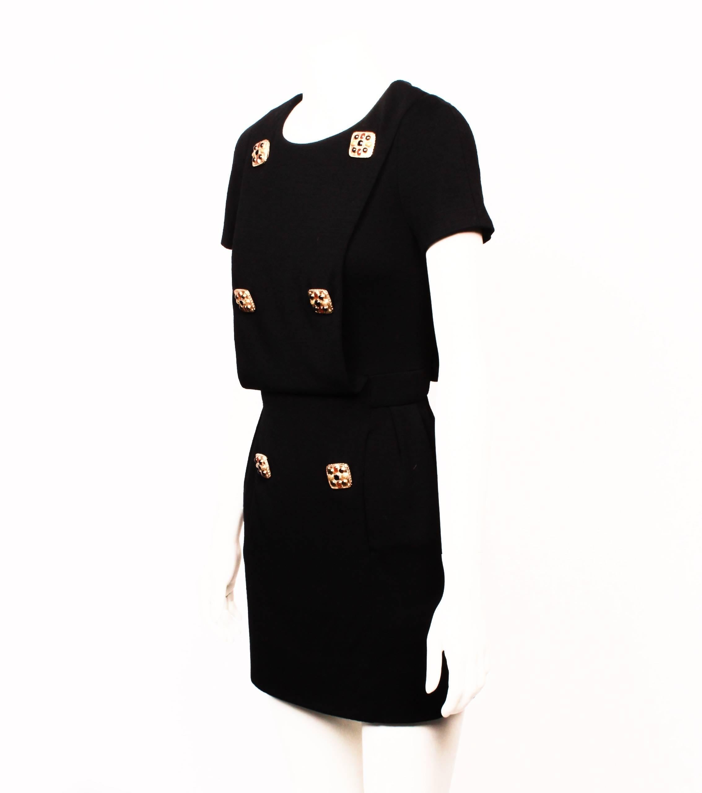 CHANEL black wool jersey short sleeve mini dress with ornate jewelled buttons. From Chanel's 2011 Pre-Fall Paris-Byzance Inspired Collection. 
Draped open panels at front and back. 
Front of dress is embellished with six gold-tone metal Byzantine