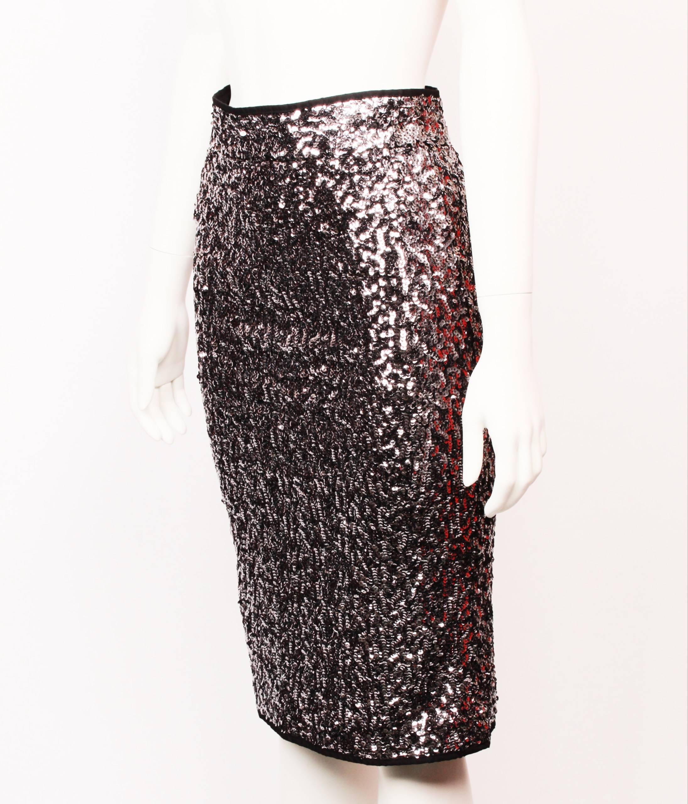 Alluring Karl Lagerfeld gunmetal grey sequin knee length fitted skirt. Features a waistband with hook and eye closure. Back split and invisible zipper. 