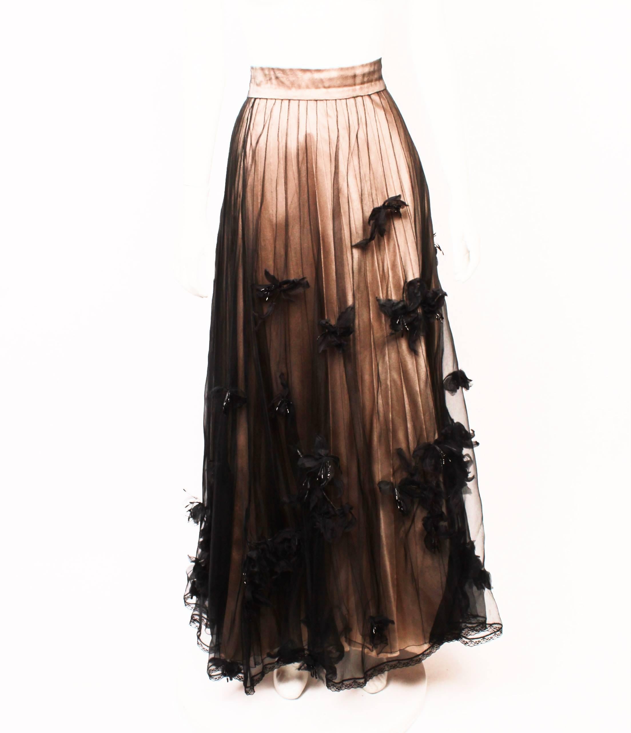 Chanel sheer silk organza evening skirt with silk flowers. 
Beautiful full length evening skirt. Layers of silk organza and tulle with lace detail and appliquéd flowers. Black sheer layers gently fall over layers of a nude silk and lace underskirt.  