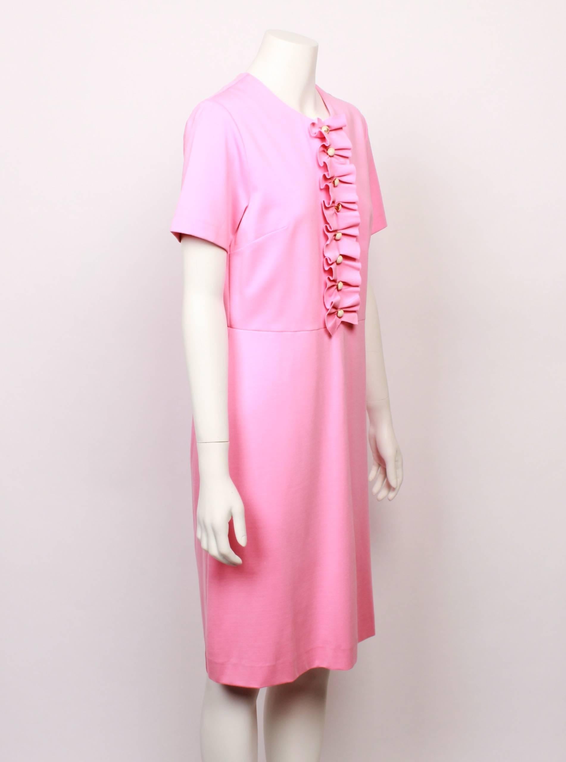 Wonderful musk pink Gucci shell dress with feature tuxedo frill. Semi fitted shell style silhouette with centre front frill and white and gold button feature . The dress is knee length and has short sleeves. Fabric is a soft knit with a slight