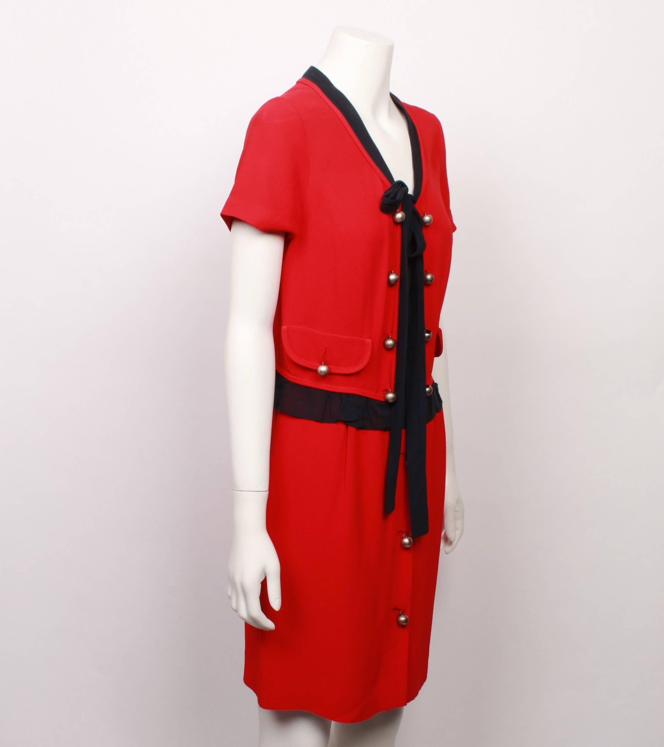 Moschino Cheap and Chic Chanel style red and black double crepe dress features cute contrasting black trim, pussy bow tie and soft frill around the waistline. 
The loose fitting bodice has 2 curved flap pockets, and is decorated with nickel domed