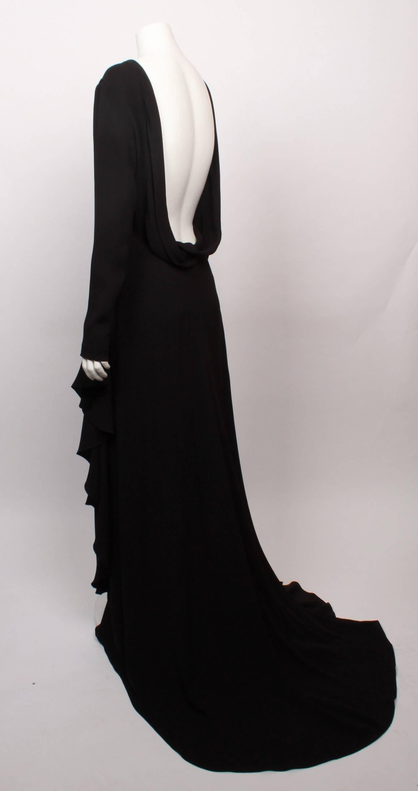 Amazing and elegant CHRISTIAN DIOR long sleeve backless black silk crepe Red Carpet evening gown. This item has never been worn and comes with original tag from Bergdorf Goodman attached showing US$7000 pre-tax.
The gown features a stunning and