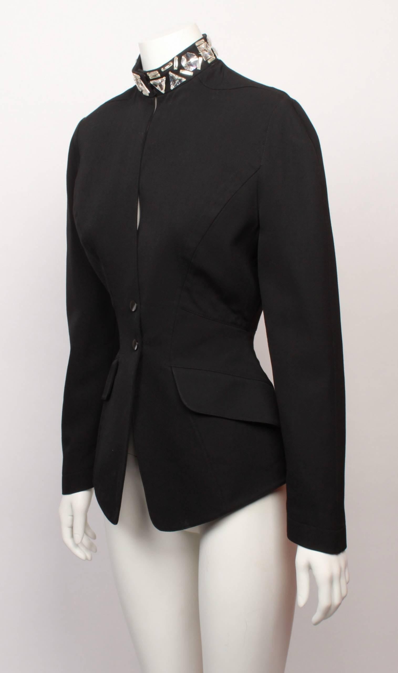 Iconic 1980s sculptural and fitted Thierry Mugler black wool jacket with jewelled crystal collar.
The jacket is panelled to create a dramatic nipped in waist, and has soft, rounded shoulders, flap feature pockets and black press stud fastening.