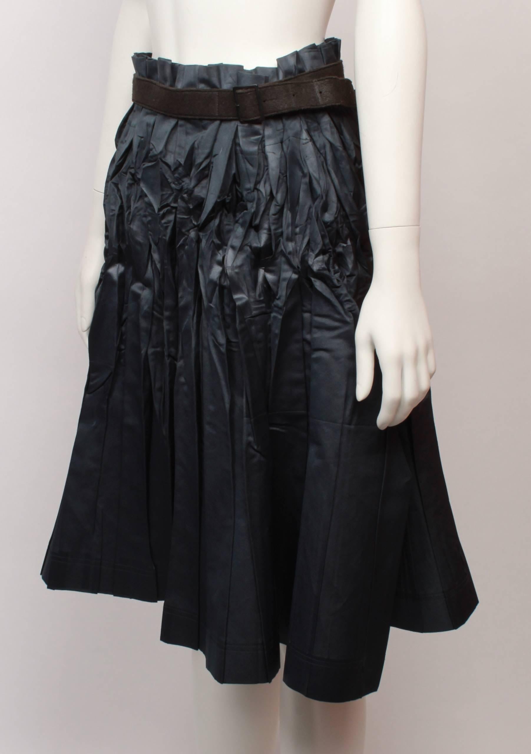 Issey Miyake Loosely Pleated Dark Charcoal satin wrap skirt with belted waistband and kilt style tabs to fasten. 
Satin is crushed and crumpled from the waist to the hip and then softens from the hip to the hemline. 
