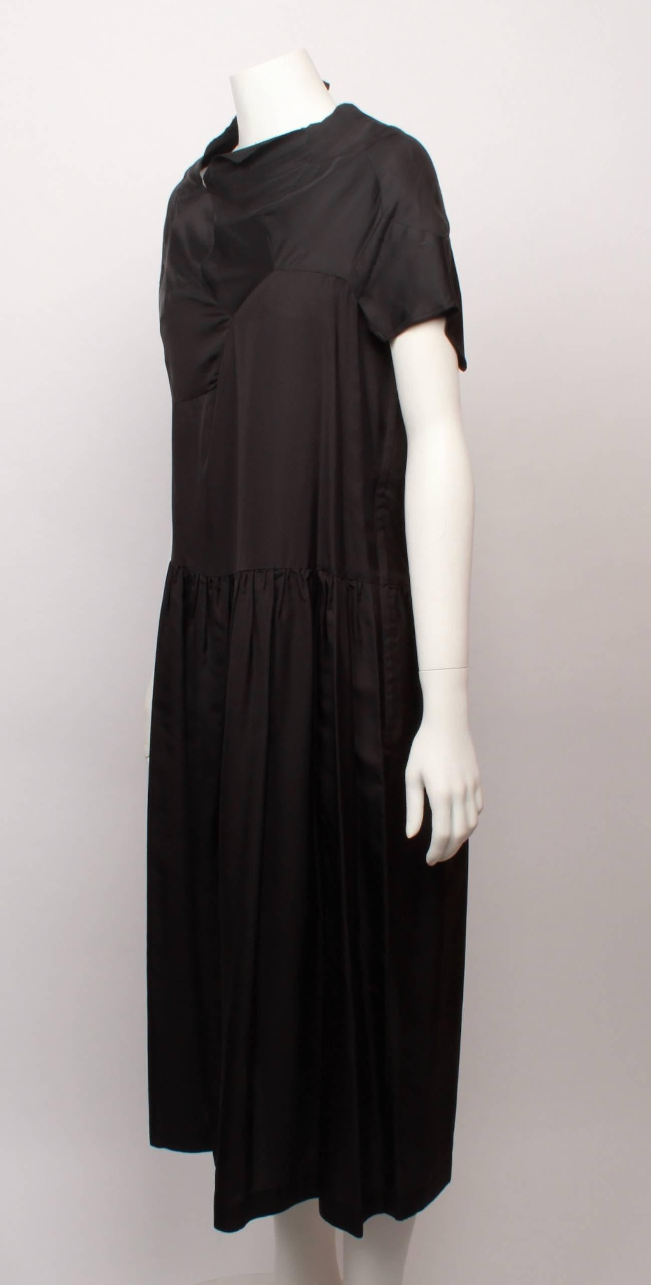Comme des Garcons hi tech black synthetic dress with geometric panelled bodice and asymmetric neckline and capped sleeve. Dress features dropped waist and gathered skirt from hip. 
Label is dated AD2008. 
