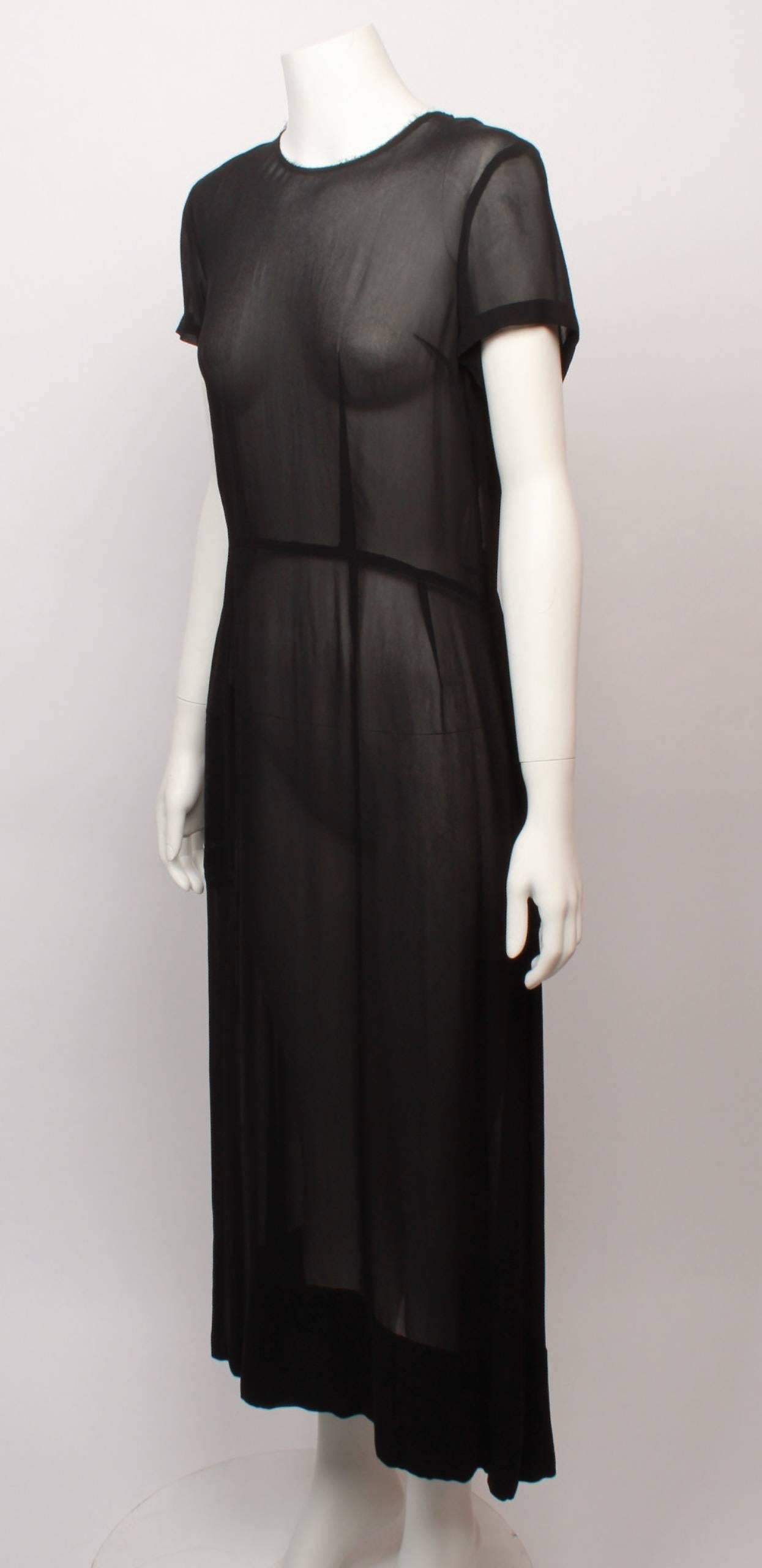 Comme Des Garcons shell dress in sheer black georgette. Features short sleeve, fitted waistline and exposed nickel zipper back closure. Below the knee flared hemline.  Label is dated AD 2000.
An amazing example of Comme Des Garcons timeless