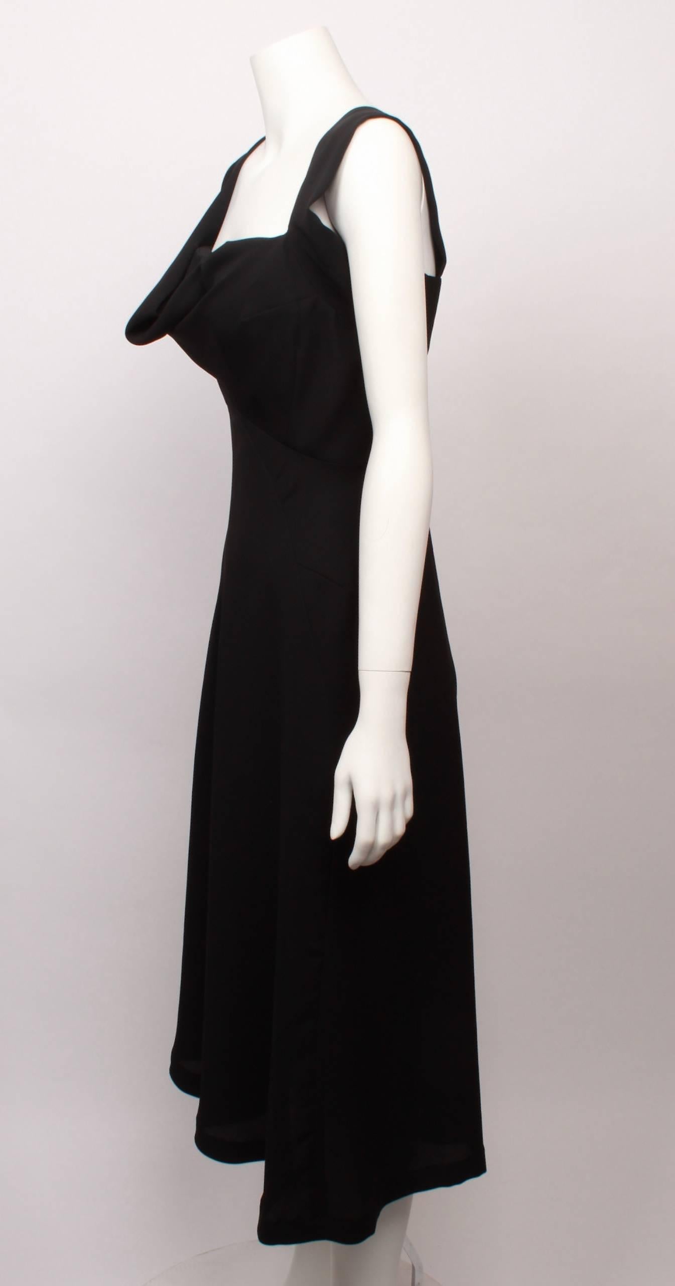 Beautiful Yohji Yamamoto black cocktail dress features draped shoulder straps and front bodice. Bust-line features padded cups within the inner construction. Dress has fitted waistline with dart details and flared hemline. Press stud closure.